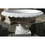 A large white painted cast iron squat pedestal garden urn, having egg & dart outer border to