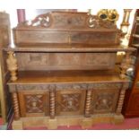A circa 1900 Flemish relief carved oak buffet sideboard, having a raised ledgeback, the further