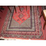 A Persian woollen red ground Shiraz rug, the central field within multiple trailing tramline