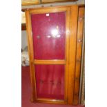 A late Victorian oak wall mounted single door glazed display case having interior brass hooks with