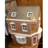 A three-storey corner dolls house, titled 'Emma's Patisserie', with sundry furniture and