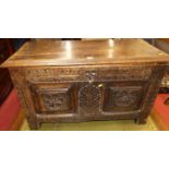 An antique floral relief carved walnut twin panelled hinge topped blanket chest, having iron end