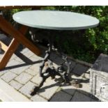 A floral decorated wrought iron based garden table, having an associated painted timber circular