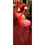 A pair of modern bright colour painted pressed metal freestanding models of flamingoes