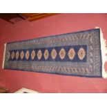 A Persian woollen blue ground Bokhara hall runner, 245 x 78cm