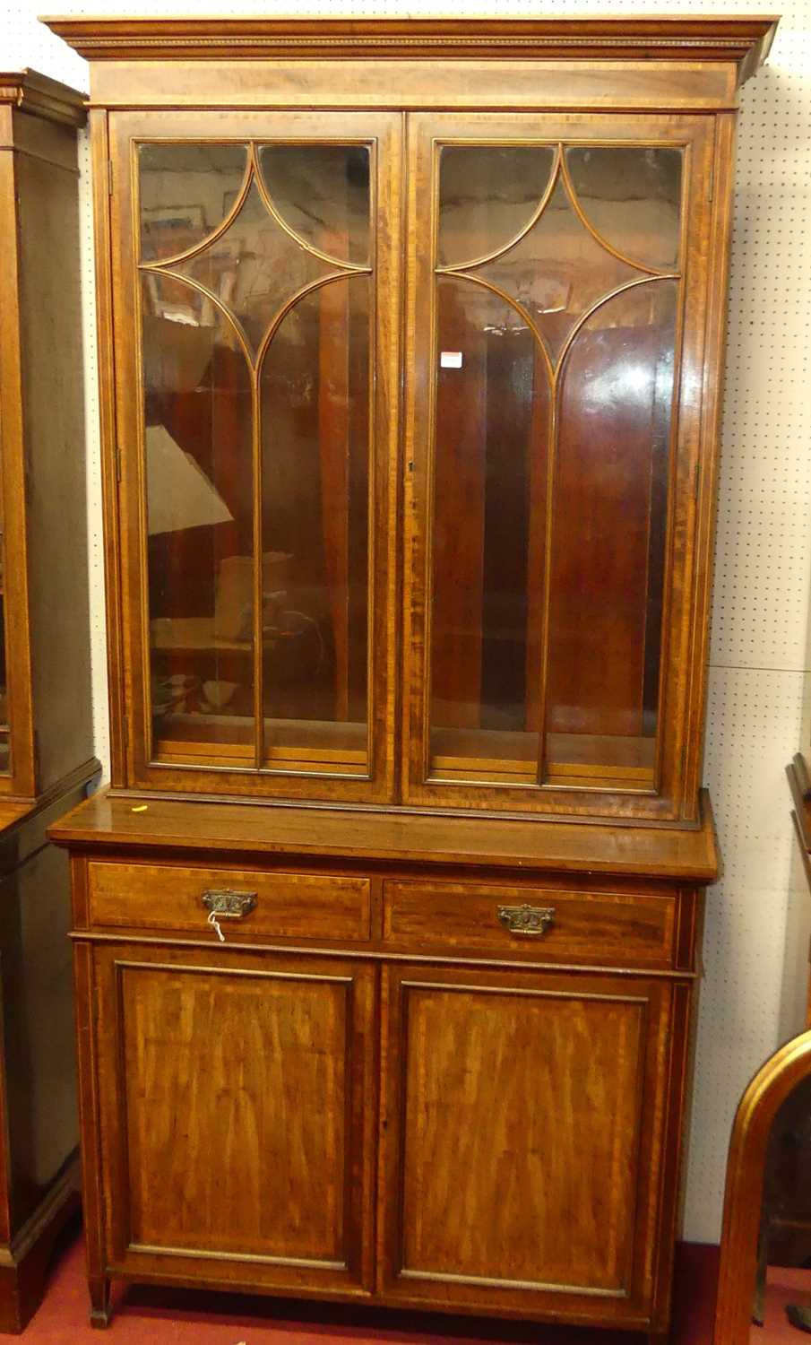 An Edwardian mahogany and satinwood crossbanded bookcase cupboard, having twin glazed upper doors,