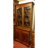 An Edwardian mahogany and satinwood inlaid bookcase cupboard, having twin astragal glazed upper