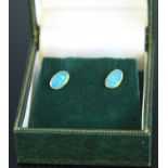 A pair of yellow metal opal set ear studs, the opal doublets each measuring approx 4.2 x 7mm, mounts