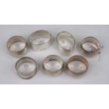 A set of four circular silver napkin rings; together with three others, gross weight 5.4ozt