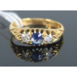 A vintage 18ct gold, sapphire and diamond three stone ring, the centre claw set sapphire weighing