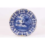 An 18th century Delft blue and white dish, decorated with a peacock, dia.35cm (a/f)