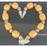 An African faux amber and filigree worked white metal long necklace, 66cm