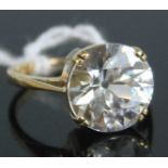 A contemporary 9ct gold and white sapphire solitaire ring, the round cut sapphire weighing approx