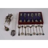 A set of six Chinese white metal tea spoons, each having a terminal decorated with Chinese