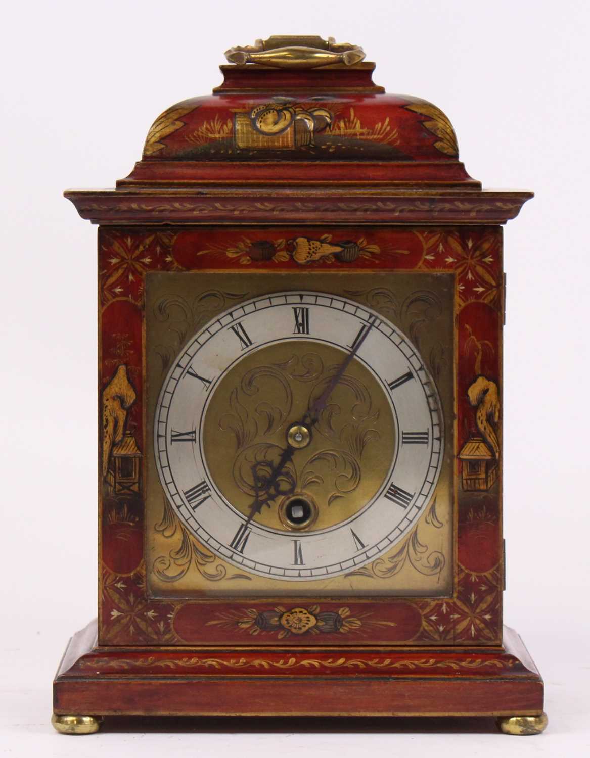 An 18th century style red lacquered cased bracket clock, the silvered chapter ring showing Roman