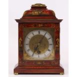 An 18th century style red lacquered cased bracket clock, the silvered chapter ring showing Roman