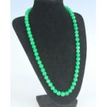 A modern Chinese beaded and knotted jadeite necklace on 14ct gold barrel clasp, 35cm