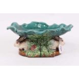 A Victorian style majolica dish, on rabbit supports, w.34cm A very modern reproduction, no