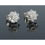 A pair of 9ct white gold diamond set flower head ear studs, setting dia.7.5mm