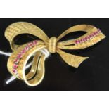 A contemporary yellow metal and pink stone set ribbon brooch, stamped 750 and tests as approx 18ct
