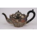 A Victorian silver bachelors teapot, of half-reeded oval form, having a scrolled ebony handle,