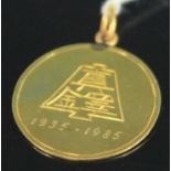 A Chinese yellow metal pendant token, with contemporary engravings, stamped 585 but tests as