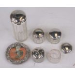 Five various glass dressing table jars, each having a silver lid, together with a repoussee