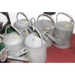 Five vintage metal watering cans, each height 45cm