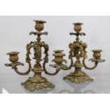 A pair of gilt metal three sconce table candlesticks in the Rococo style, height 26cm