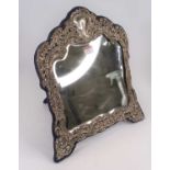 An Edwardian silver clad dressing table mirror, repoussee decorated with vines and flowers, height