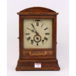 An early 20th century walnut cased mantel clock, the painted dial showing Roman numerals, having