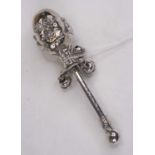 A Victorian style white metal baby's rattle, the finial in the form of a two faced head, inscribed