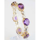 A yellow metal, amethyst and diamond bracelet, comprising six oval faceted amethysts alternating