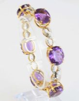 A yellow metal, amethyst and diamond bracelet, comprising six oval faceted amethysts alternating