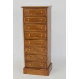 A walnut and figured walnut eight drawer chest, of narrow proportions, having a cross and feather