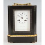 A mid-19th century French ebonised carriage clock, having gilt brass carry handle, white enamel