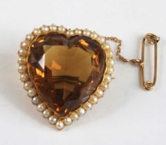 A yellow metal heart shaped citrine brooch, the citrine within a border of thirty-four 2.2mm seed