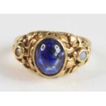 A yellow metal sapphire dress ring (tests as 18ct), comprising; an oval cabochon cut sapphire in a