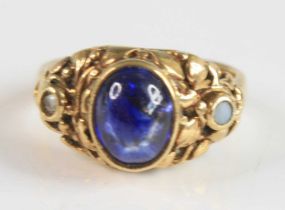 A yellow metal sapphire dress ring (tests as 18ct), comprising; an oval cabochon cut sapphire in a