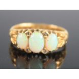 An 18ct yellow gold Edwardian opal three-stone ring, featuring three graduated oval opal cabochons