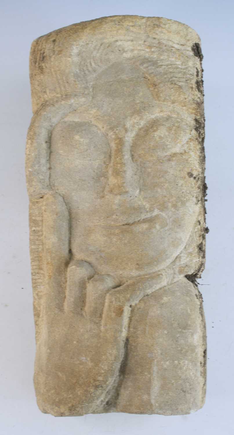 A sandstone corbel, carved as a serene face with chin resting upon a hand, Medieval style, 4.16, d.