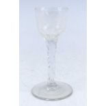 A wine glass, circa 1785, the round funnel bowl etched with a bird and flower above a faceted