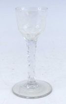 A wine glass, circa 1785, the round funnel bowl etched with a bird and flower above a faceted