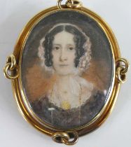 A Victorian miniature portrait mourning brooch, depicting a bust portrait of a woman wearing a