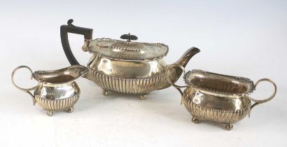 An Edwardian silver three-piece tea service, comprising teapot, twin handled sugar and cream, each