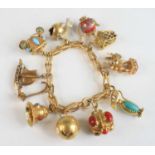 A yellow metal fancy stirrup shaped open link bracelet, having bolt ring clasp and eleven charms