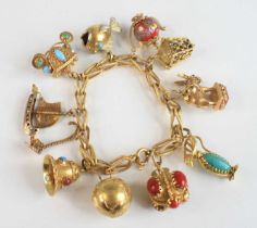 A yellow metal fancy stirrup shaped open link bracelet, having bolt ring clasp and eleven charms