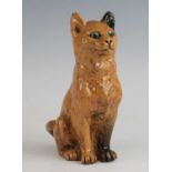 An unusual Ewenny pottery model of a cat, circa 1900, shown in seated pose with glass eyes, having a