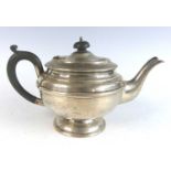 A George VI silver teapot, of plain banded squat circular form, having ebonised C-scroll handle with