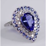 A white metal, tanzanite and diamond pear shaped cluster ring, featuring a centre pear cut tanzanite